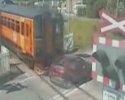 Une voiture passe juste devant un train