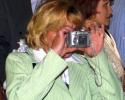 Une blonde qui prend une photo avec un numérique
