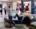 Il pousse une fille dans la fontaine d'un centre commercial